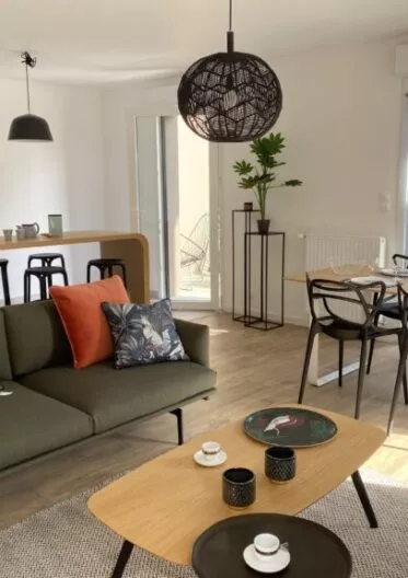 Intérieur d'un appartement neuf composé d'un salon et d'une salle à manger. Canapé, table basse, table et chaise, et mobilier de décoration dans une atmosphère conviviale.