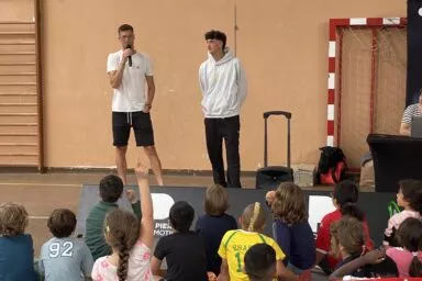 Des enfants posant des questions à deux joueurs professionnels de tennis dans le cadre de l'événement Open en Quartier organisé par Pierre Promotion et l'agence RivaCom.