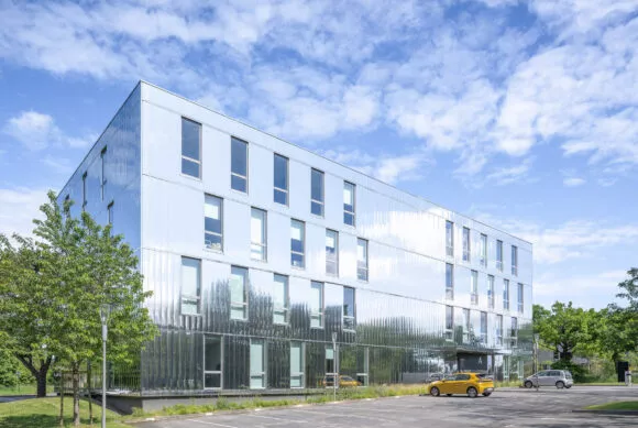 Façade extérieure et parking du programme tertiaire Les Reflets situé à Saint-Herblain, près de Nantes. Un ensemble d'immobilier neuf réalisé par Pierre Promotion.