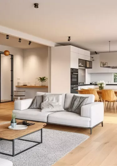 Intérieur d'un appartement lumineux : salon, cuisine et salle à manger.