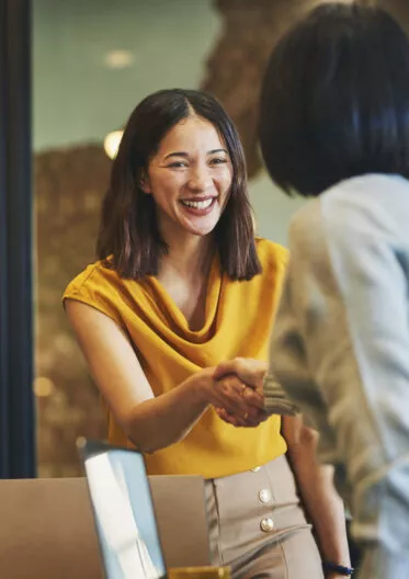 Deux femmes se serrant la main après avoir eu un entretien professionnel dans la promotion immobilière.